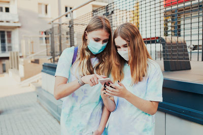 Young woman using mobile phone in city