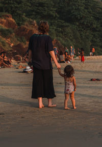 Rear view of friends standing on beach