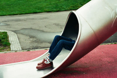 Low section of boy playing on slide in playground