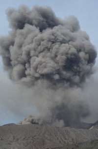 Smoke emitting from volcanic mountain against sky