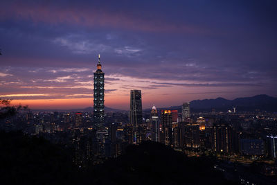 Illuminated buildings against sky at night