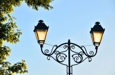 Low angle view of illuminated street light against clear sky