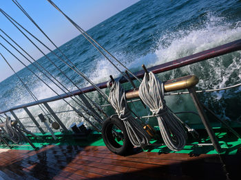 Close-up of ship sailing in sea against clear sky