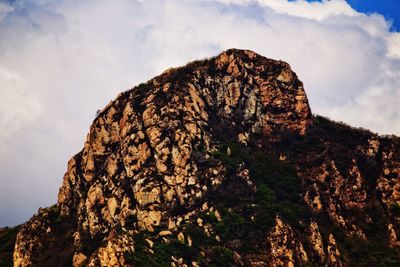 Low angle view of rocky mountain against sky