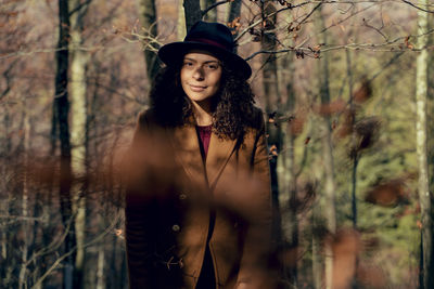 Portrait of young woman standing in forest