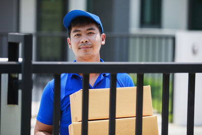 Portrait of young man standing against wall