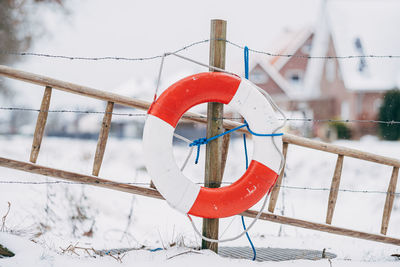 Lifebelt and ladder in front of snowy landscape