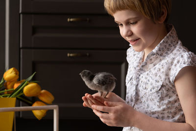 Girl holding baby chicken in hand