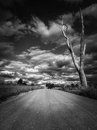 Road amidst field against sky