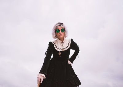 Low angle view of woman standing against sky