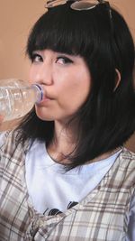 Portrait of a beautiful young woman drinking glass