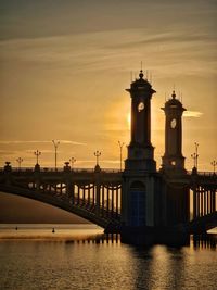 Bridge over river against sky during sunset