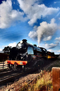 Train on railroad tracks against sky