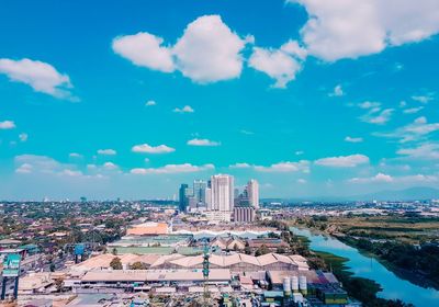 Aerial view of city buildings against cloudy sky