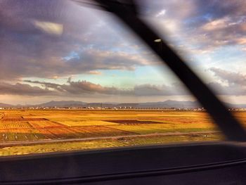 Scenic view of field against cloudy sky