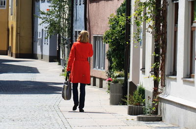 Rear view of woman walking on sidewalk