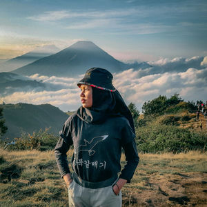 Woman standing on field against sky