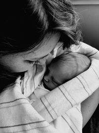 Close-up of mother holding newborn baby at home