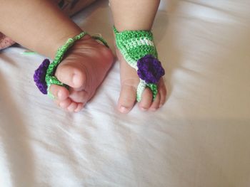 Close-up of baby feet with socks on bed