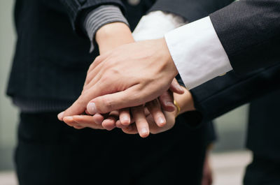 Cropped image of business people stacking hands at office