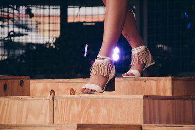 Low section of woman standing on railing