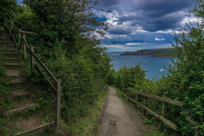 Scenic view of sea by trees against sky