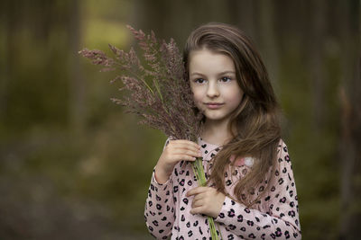 Portrait of girl holding plant