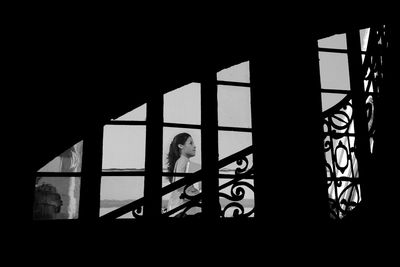 Portrait of woman standing by window in building