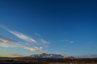 Scenic view of mountains against blue sky