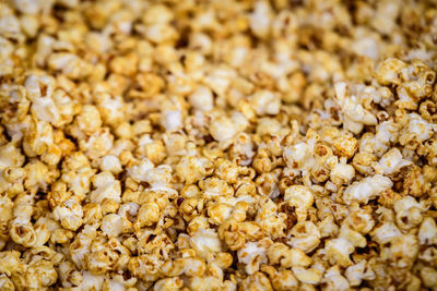 Sugar glazed fresh popcorn displayed for sale at a street food market, photographed with soft focus