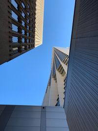 Low angle view of modern building against clear blue sky