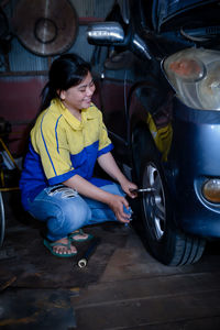 High angle view of young woman sitting on car