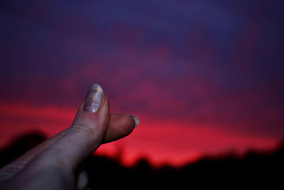 Midsection of person against sky during sunset