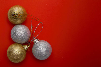 Directly above shot of christmas ornaments on red background