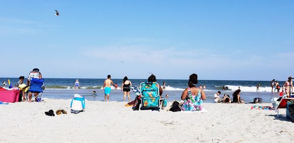 People at beach against sky