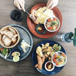 Directly above shot of hands eating food served on table