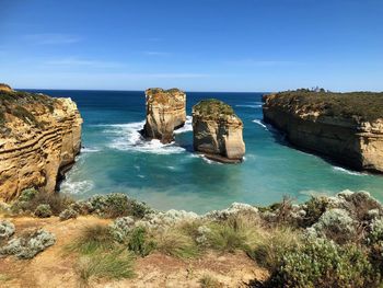 Scenic view of rocks in sea against blue sky