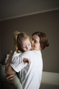 Mother embracing disabled child at home