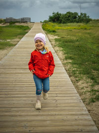 Full length portrait of girl standing on footpath