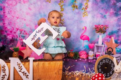 Portrait of cute baby girl decorating birthday scene