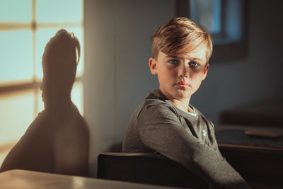 Side view of young woman sitting on table