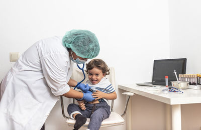 Female doctor examining kid little child boy.