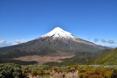 Scenic view of snowcapped mountains against clear blue sky