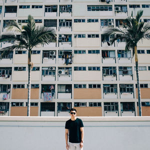 Man standing against apartment building