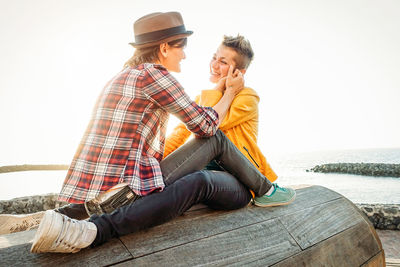 Lesbian couple sitting at beach