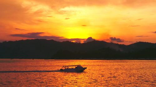 Boat sailing in sea at sunset