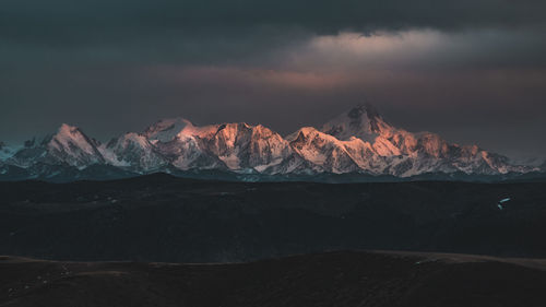 Scenic view of snowcapped mountains against sky during sunset