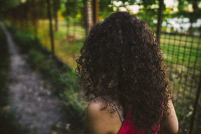 Rear view of woman against tree trunk