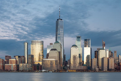 Modern buildings in city against cloudy sky