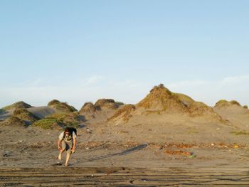 Man standing on sand against sky